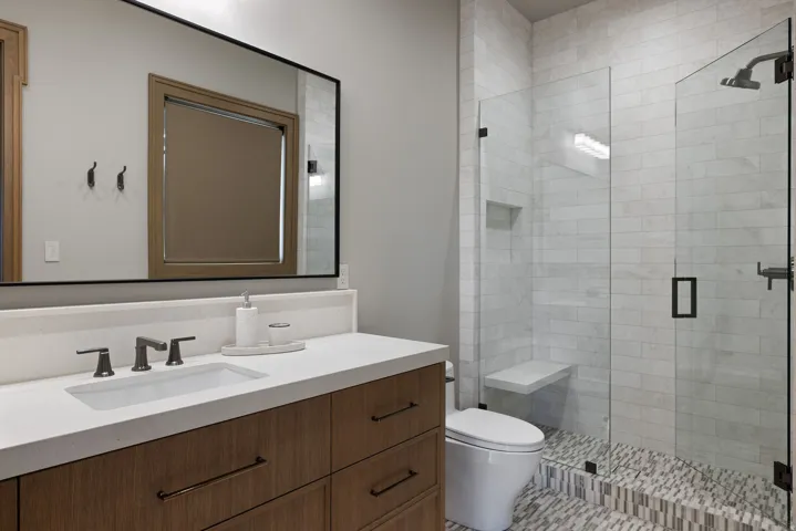 Wood-finish vanity with an integrated sink and matte black fixtures