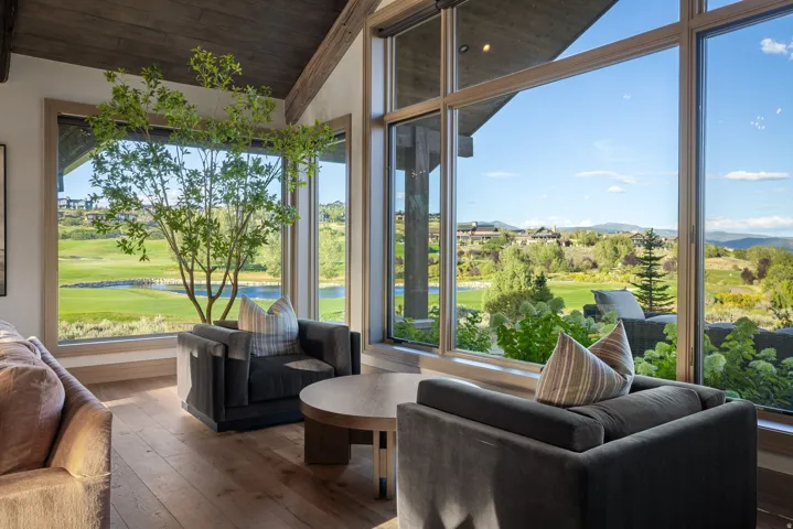 Vaulted wood-paneled ceilings, wood flooring, and extensive window-wall framing outdoor scenery
