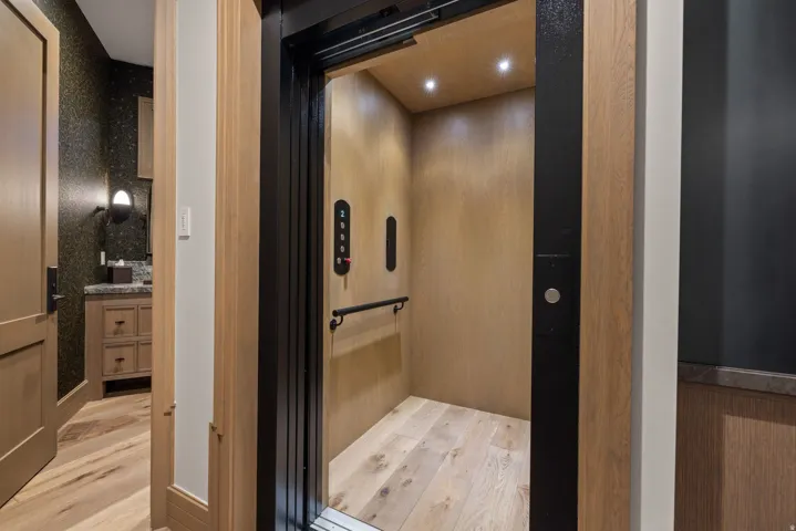 In-home elevator with wood-finish interior and recessed lighting