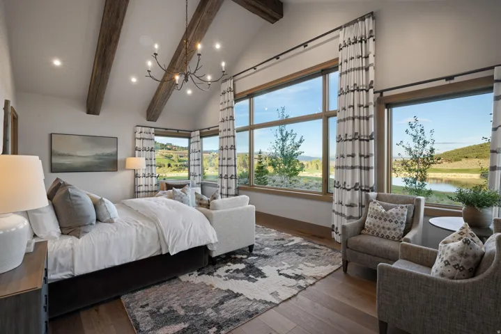 Vaulted ceiling with exposed wood beams and a multi-arm chandelier