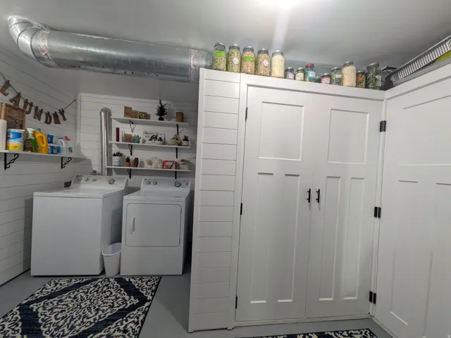 Shiplap-style wall paneling, built-in shelving, white cabinetry with black hardware, and exposed ductwork
