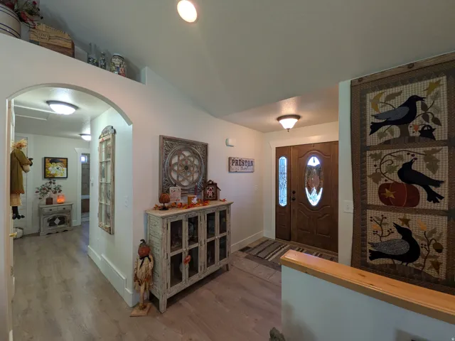 Welcoming foyer featuring hardwood flooring, recessed ceiling lighting, and custom built-in cabinetry with glass-front doors