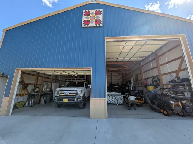 Blue metal siding structure with dual overhead doors