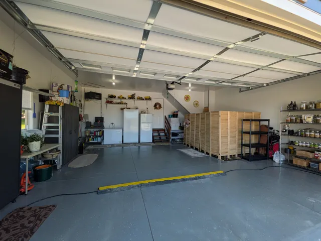 Spacious garage with epoxy-coated flooring, overhead lighting, and interior access