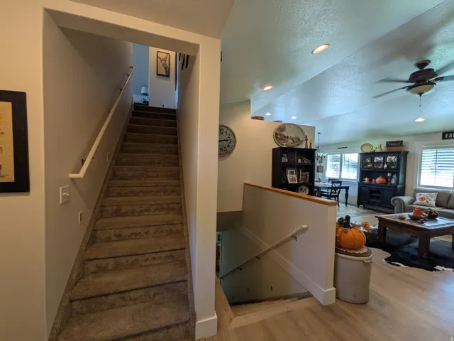 Carpeted staircase with wall-mounted handrail