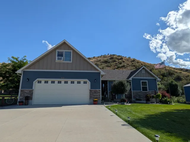 Craftsman-style exterior with blue siding and stone accents
