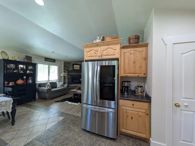Tile flooring, wood-finish flooring, recessed lighting, and a stone fireplace