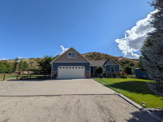 Contemporary exterior with a two-car garage, stone accents, and a landscaped front yard