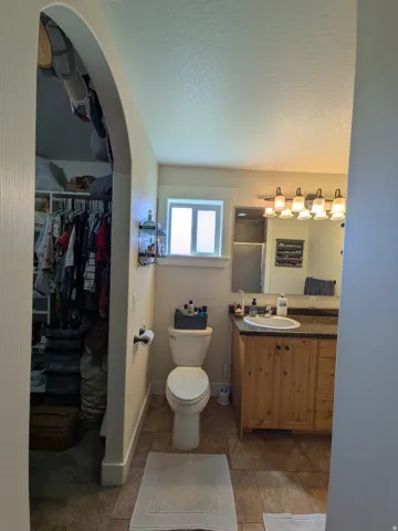 Master bath and closet. Arched doorway entry to a built-in closet system
