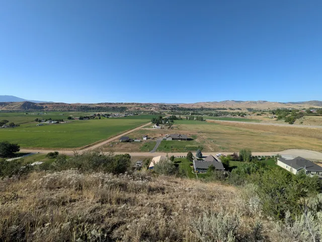 Expansive rural landscape featuring distant green fields and rolling hills