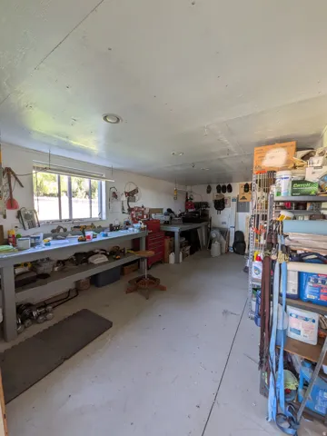 Concrete flooring, recessed ceiling lighting, a broad window, and built-in workbench surfaces