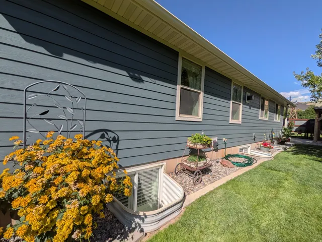 Siding exterior with multiple windows, complemented by a landscaped planting bed with gravel
