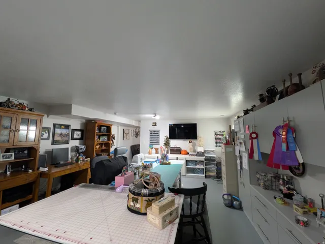 Spacious room featuring extensive built-in cabinetry, a dedicated desk area, and overhead lighting