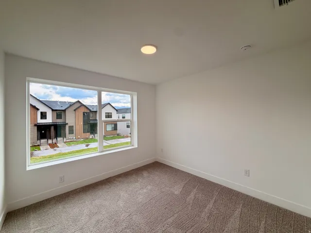 Basement bedroom with wall-to-wall carpeting and large picture window