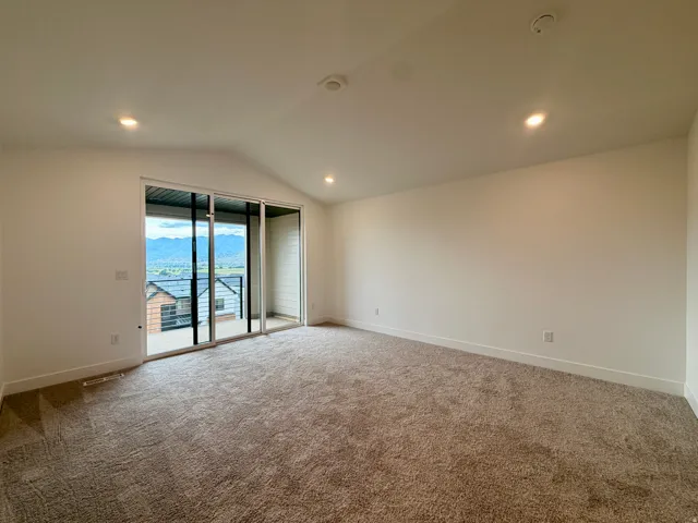 Owner's suite with vaulted ceiling with recessed lighting