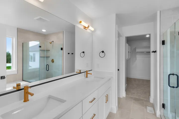 Dual vanity with quartz countertop, undermount sinks, and gold-finish fixtures
