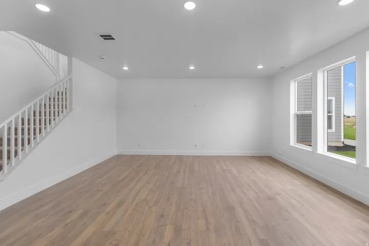 Wood-finish flooring throughout, complemented by recessed lighting and multiple windows