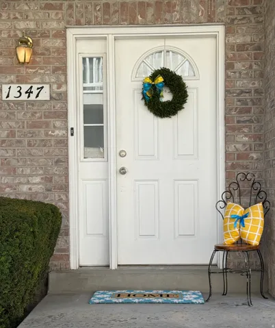 Brick exterior featuring a white paneled entry door with an arched transom window and a side light