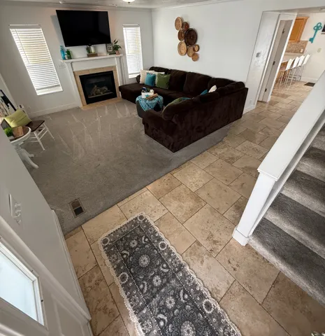 Living room featuring a fireplace with a mantel, recessed lighting, and carpet flooring
