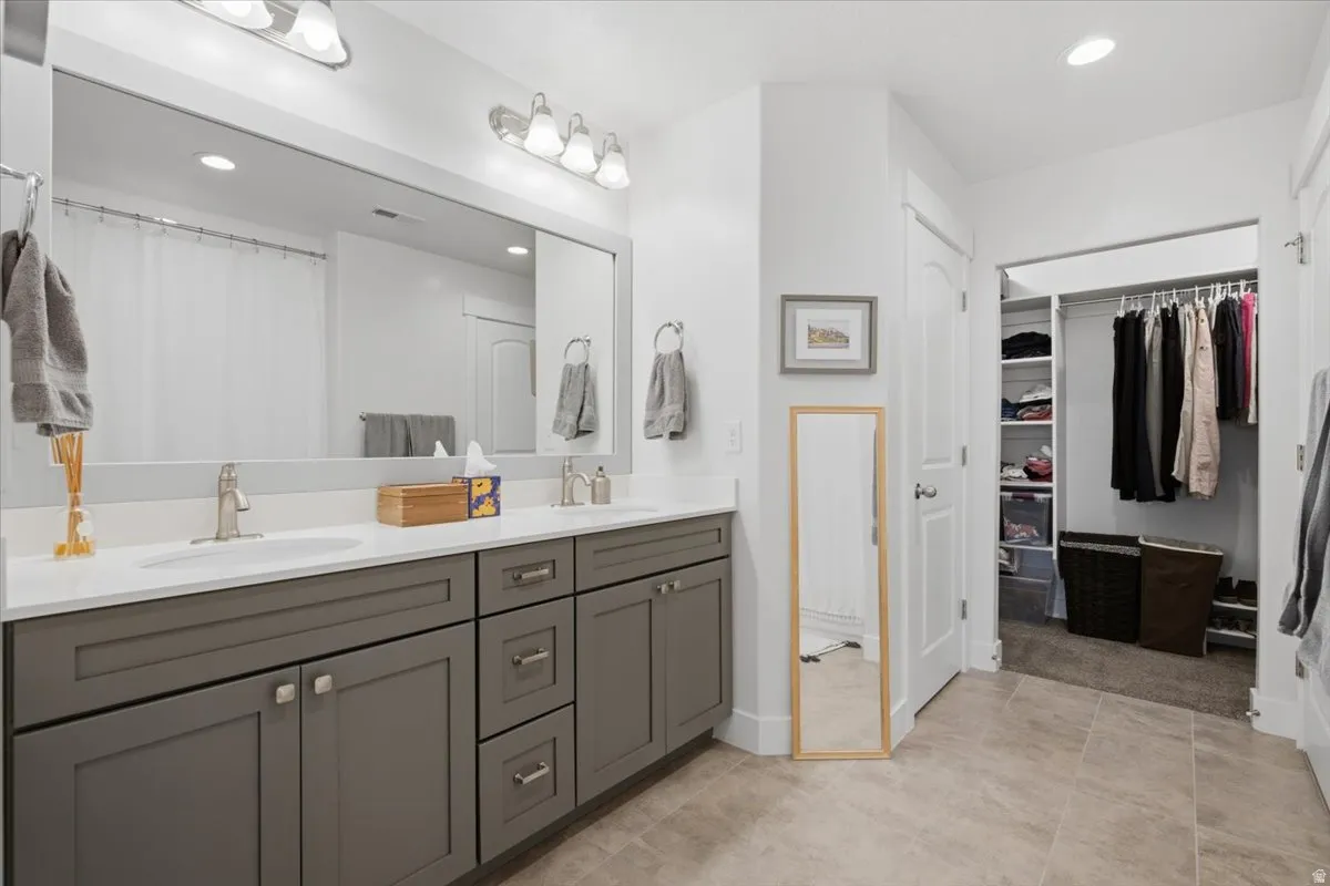Dual vanity with white countertops, undermount sinks, and brushed nickel fixtures
