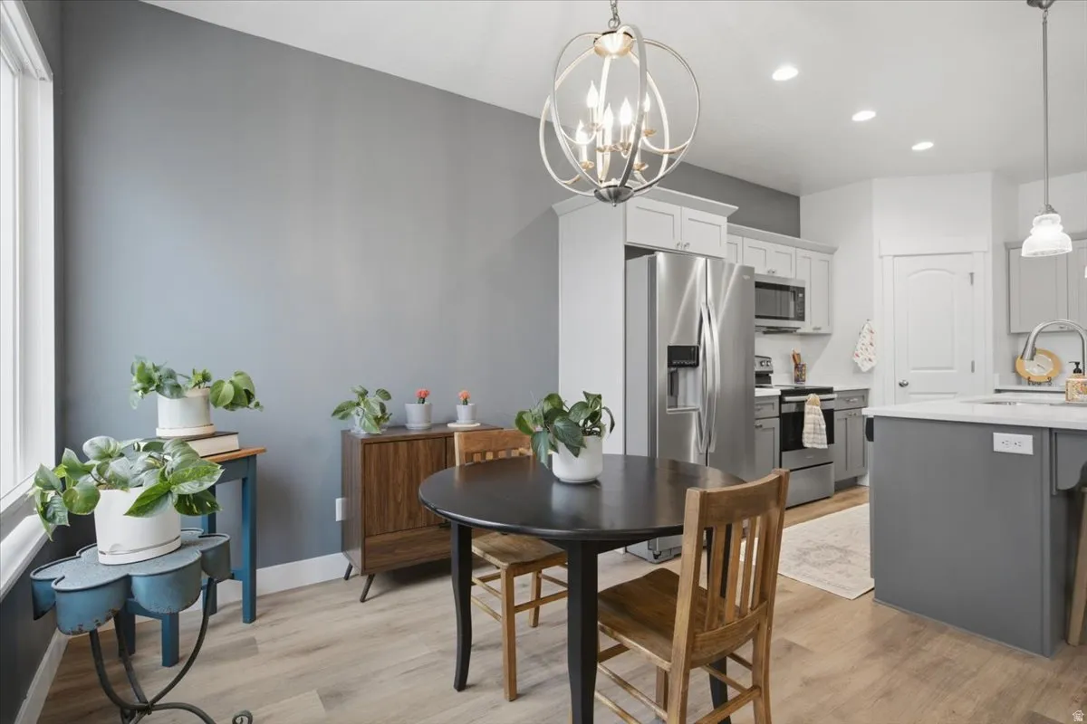 Recessed lighting, stainless steel appliances, wood-finish flooring, island with countertop, and modern lighting fixture