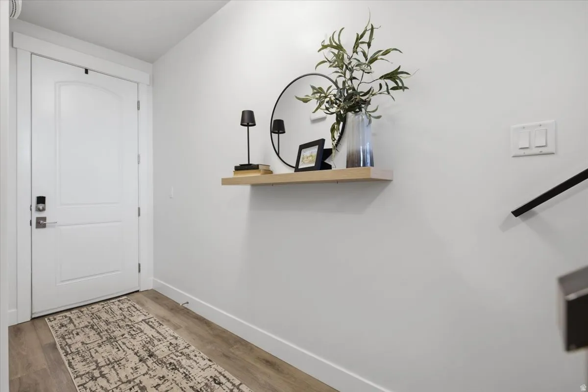 White painted interior door with smart lock hardware and a light wood-finish floor
