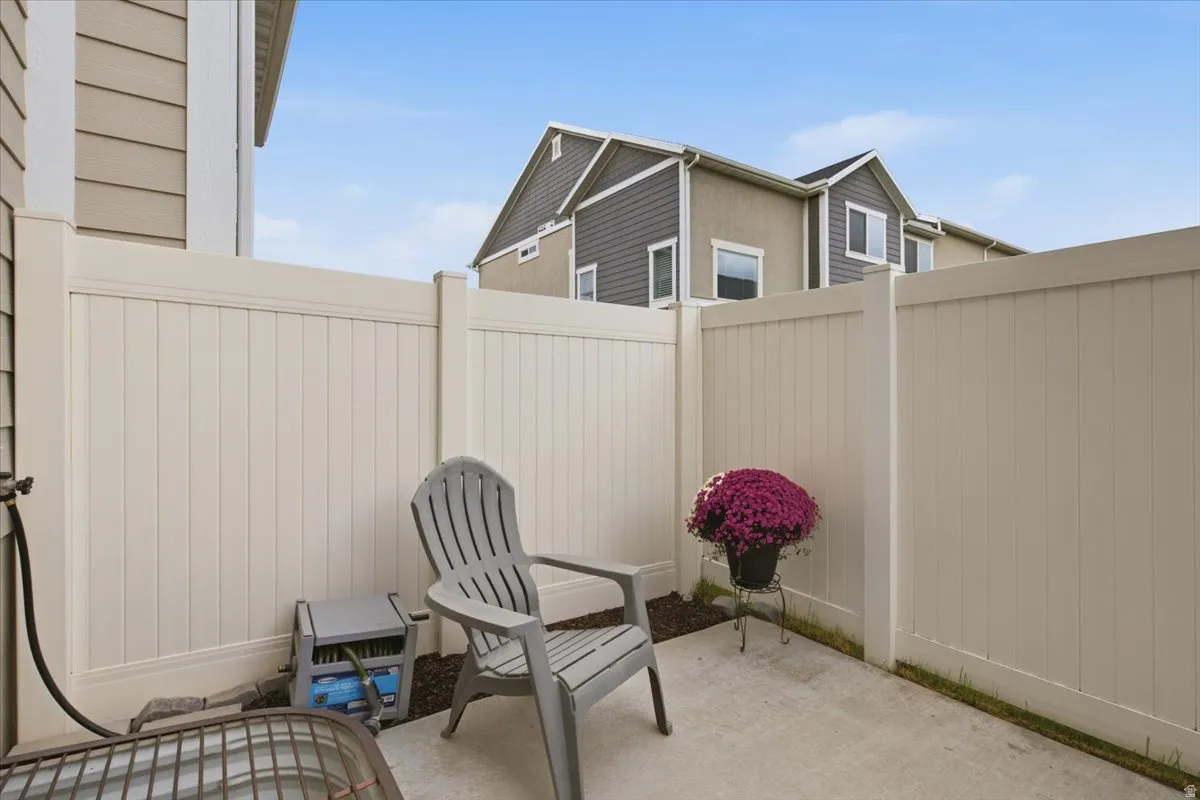 Private concrete patio area enclosed by beige fencing