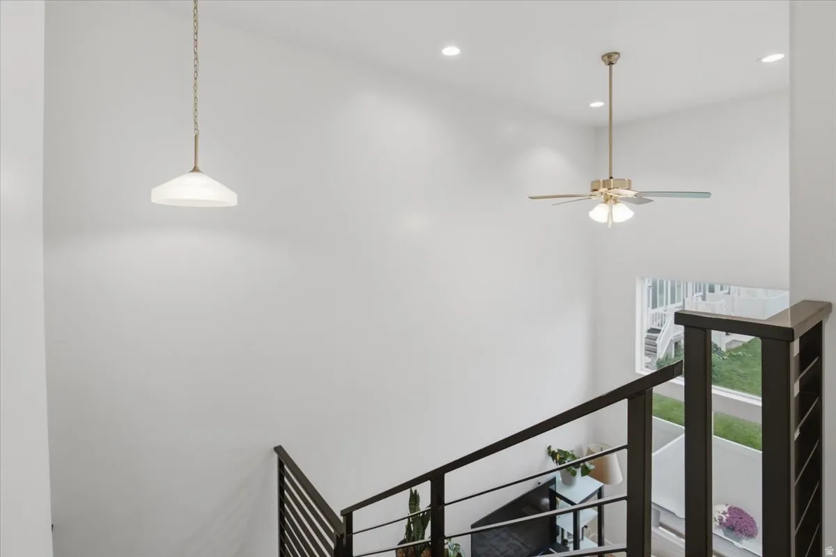 Modern upper-level landing featuring polished concrete flooring, black metal stair railing, and contemporary lighting
