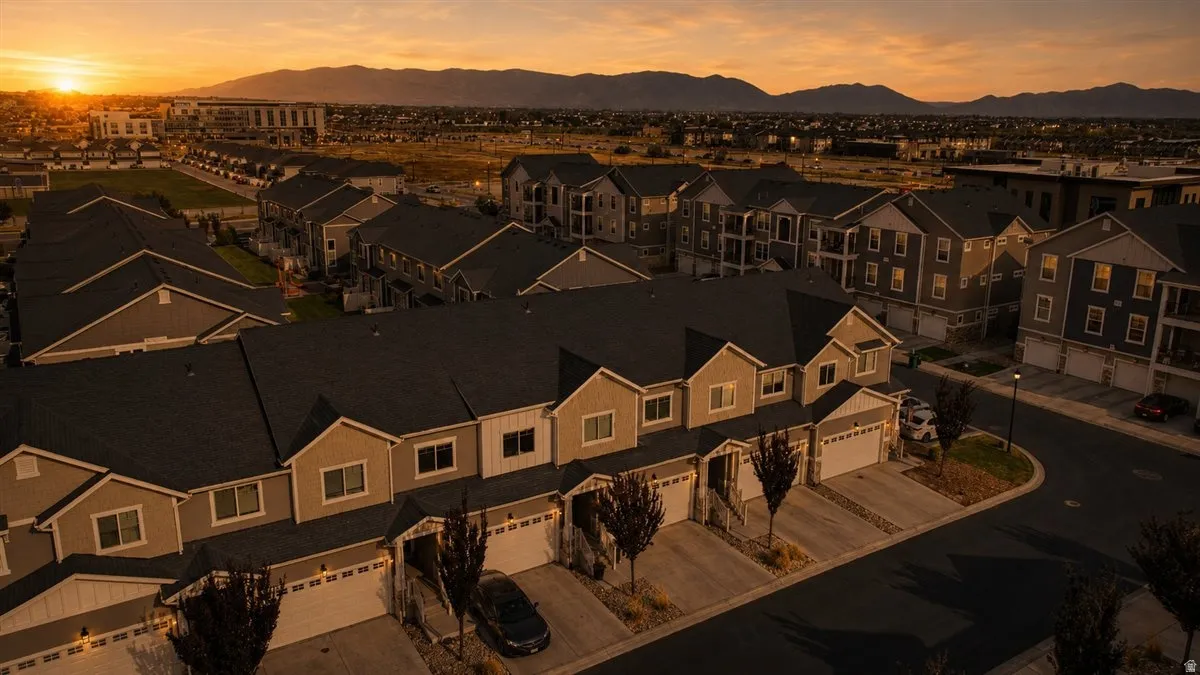 Townhome community with pitched roofs, individual garages, and mountain scenery