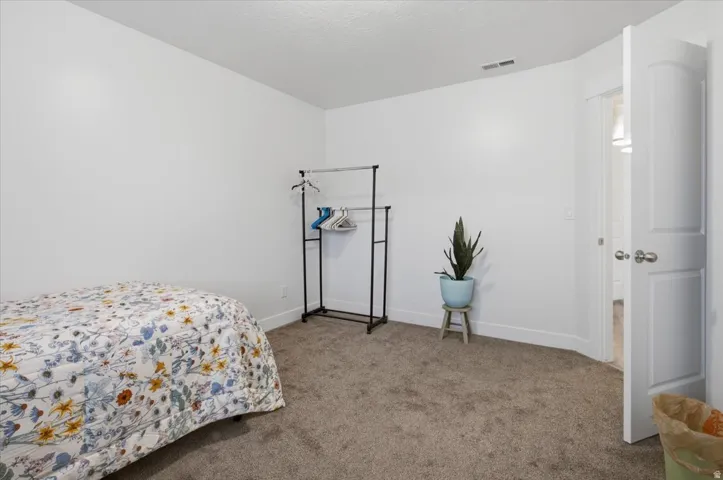 Neutral wall paint, carpet flooring, and a white paneled door with brushed nickel hardware