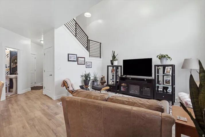Expansive living area featuring high ceilings, wood-finish flooring, and a modern stair railing