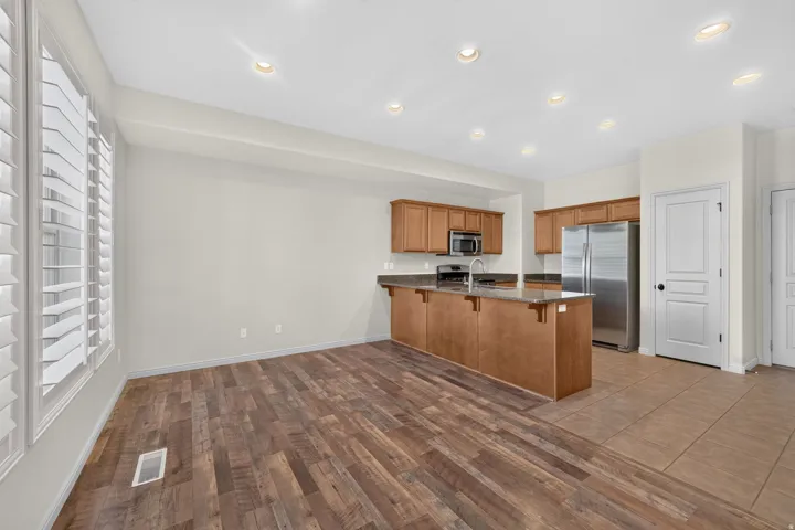 Kitchen with wood-finish cabinetry, stainless steel appliances, and a breakfast bar