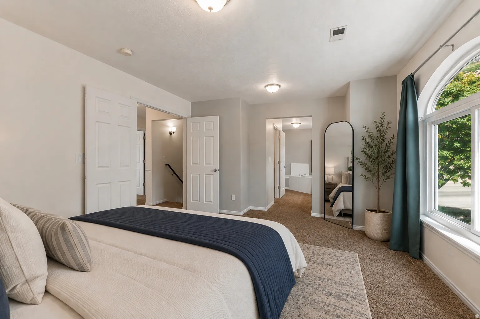 Oversized primary suite bathed in natural light, private door to spa-like en suite bathroom