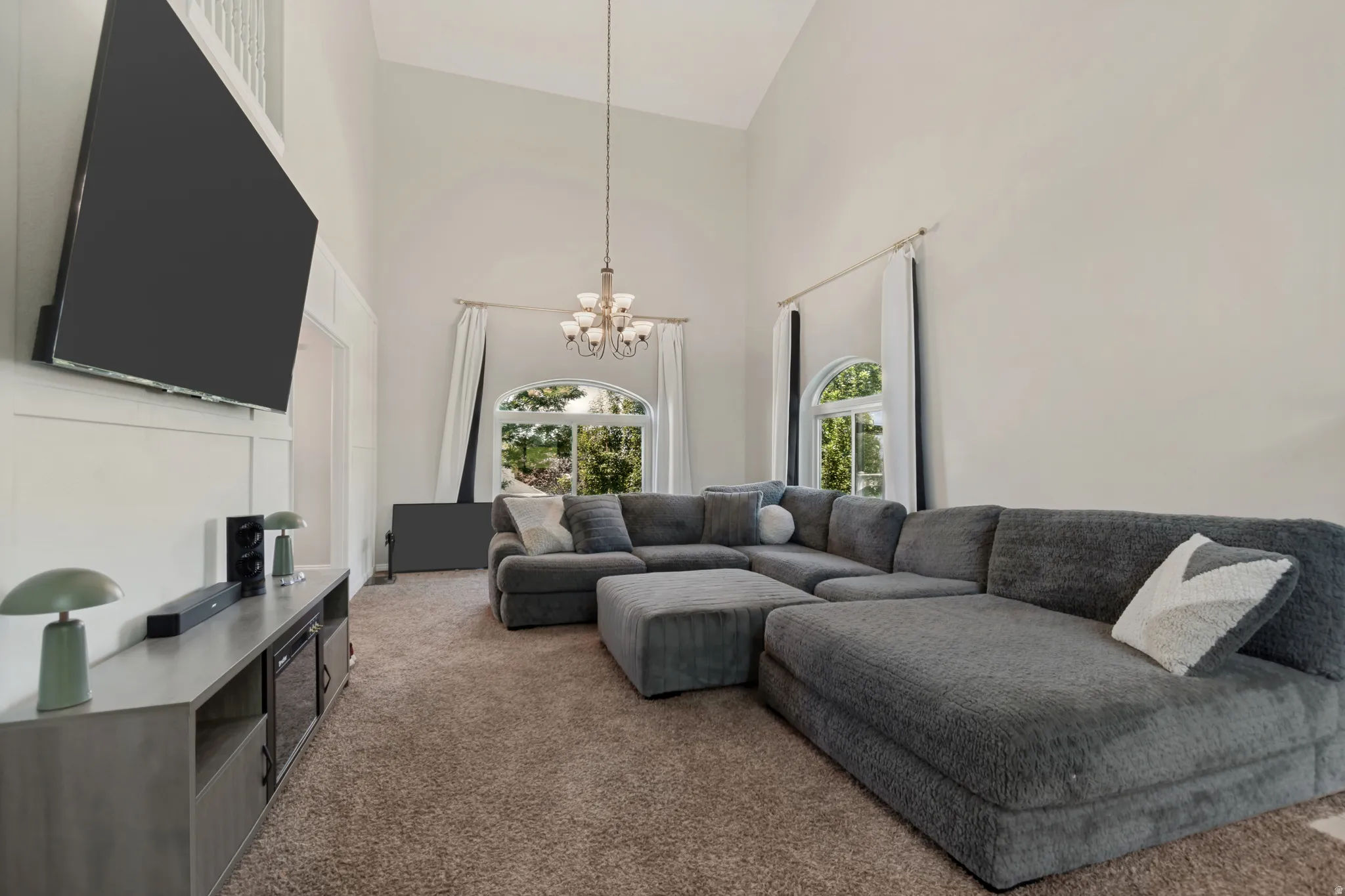 Impressive great room featuring vaulted ceilings, striking modern decorative trim, large windows for lots of natural light and a cozy fireplace for relaxing and entertaining