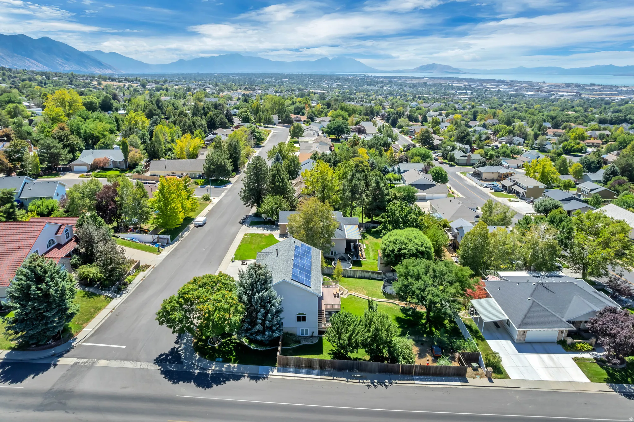 Expansive residential setting with mature trees and mountain scenery