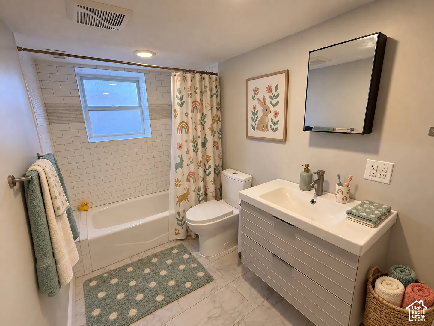 Bathroom featuring a single window, subway tile bath surround, built-in bathtub, vanity with integrated sink, and wall-mounted mirror