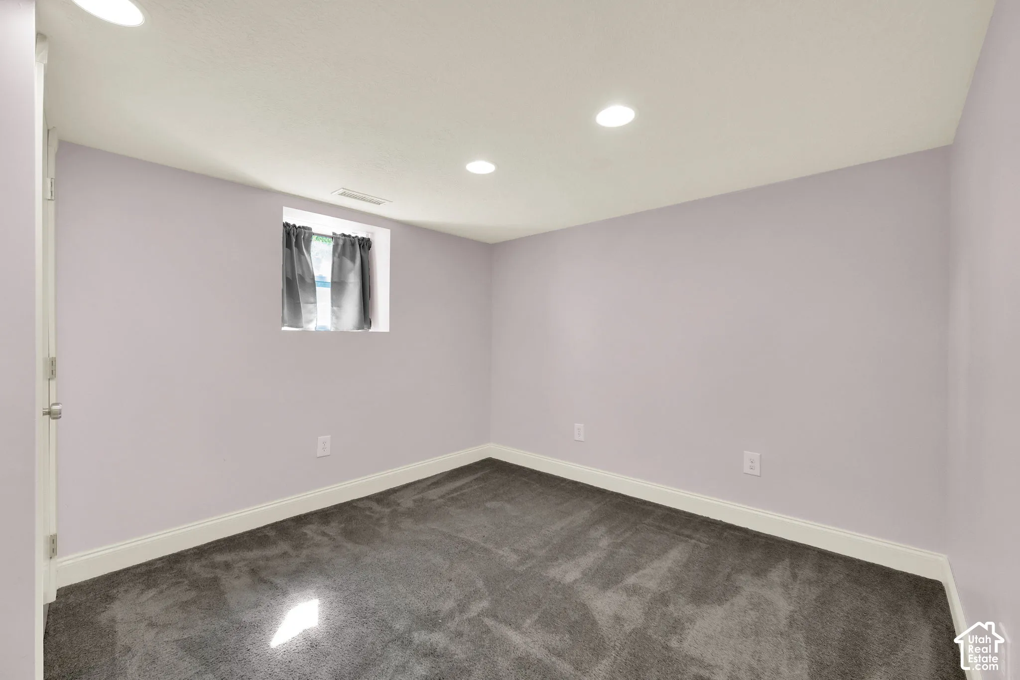 Recessed lighting, plush carpeting, white trim, and a window opening