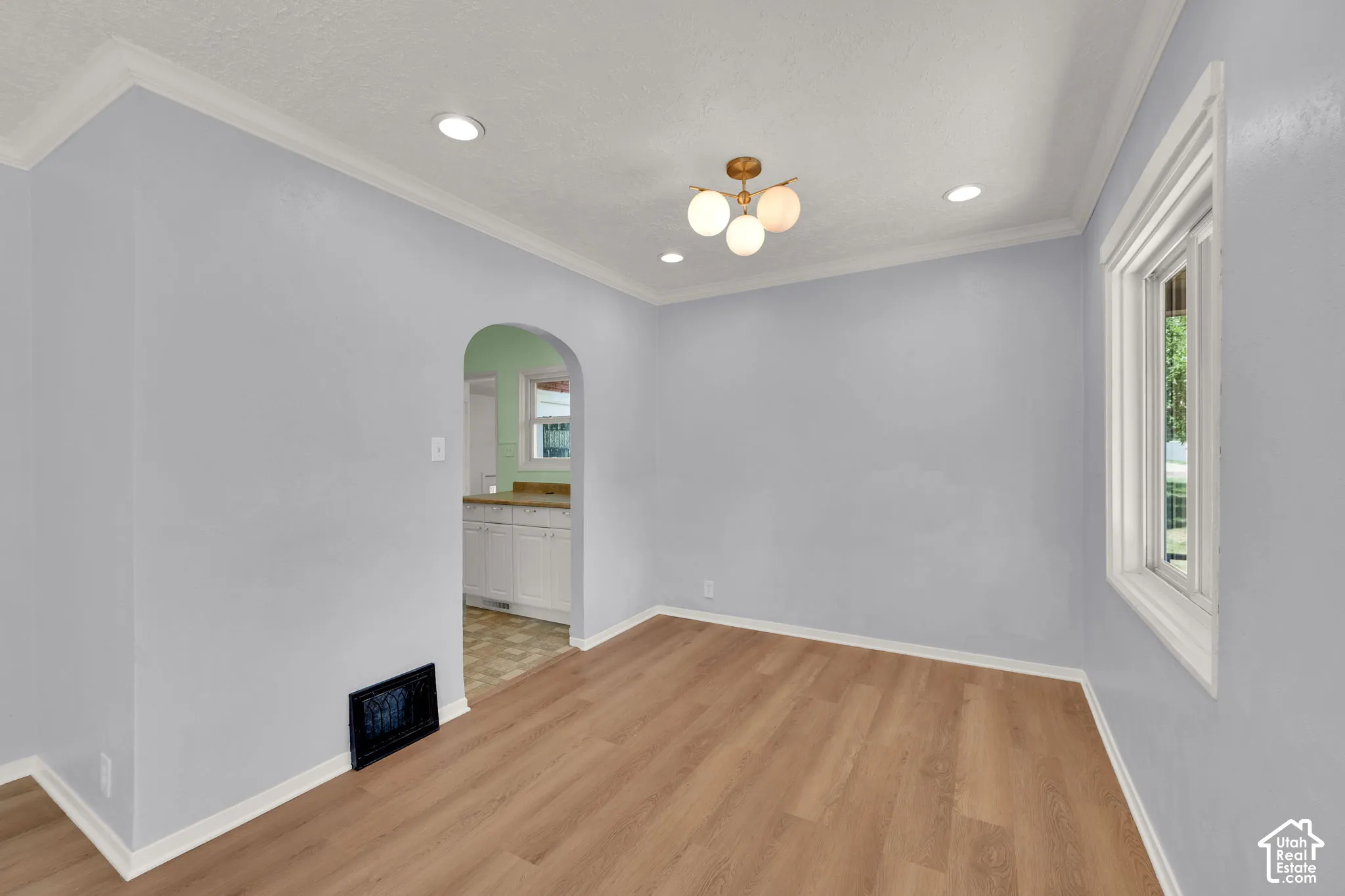 Wood-finish flooring with white trim and crown molding