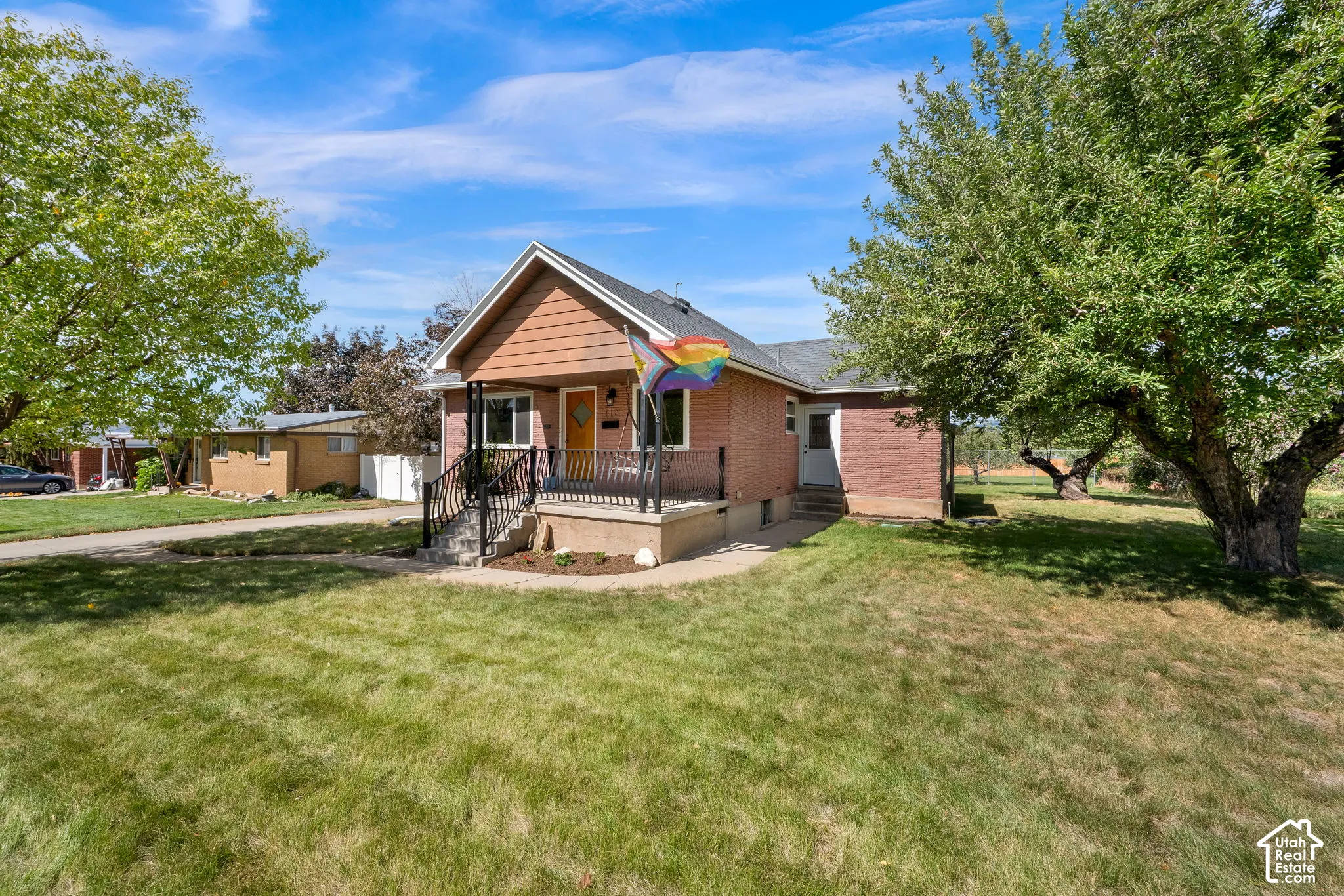 Brick and siding exterior with a covered front porch, concrete steps, and metal railings