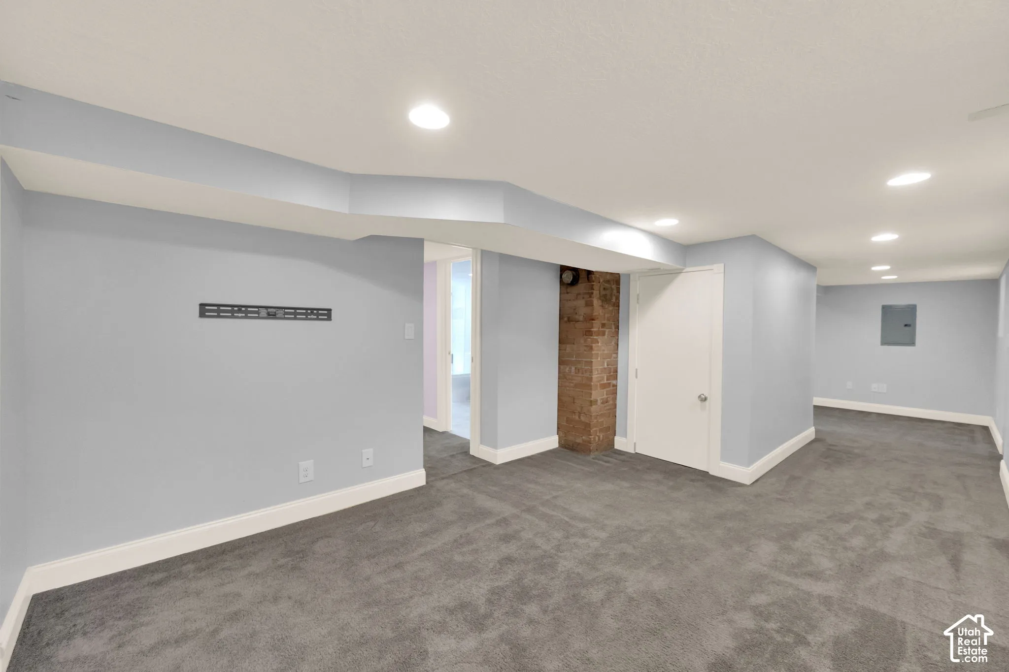 Spacious room with recessed lighting, light gray walls, gray carpeting, and white trim