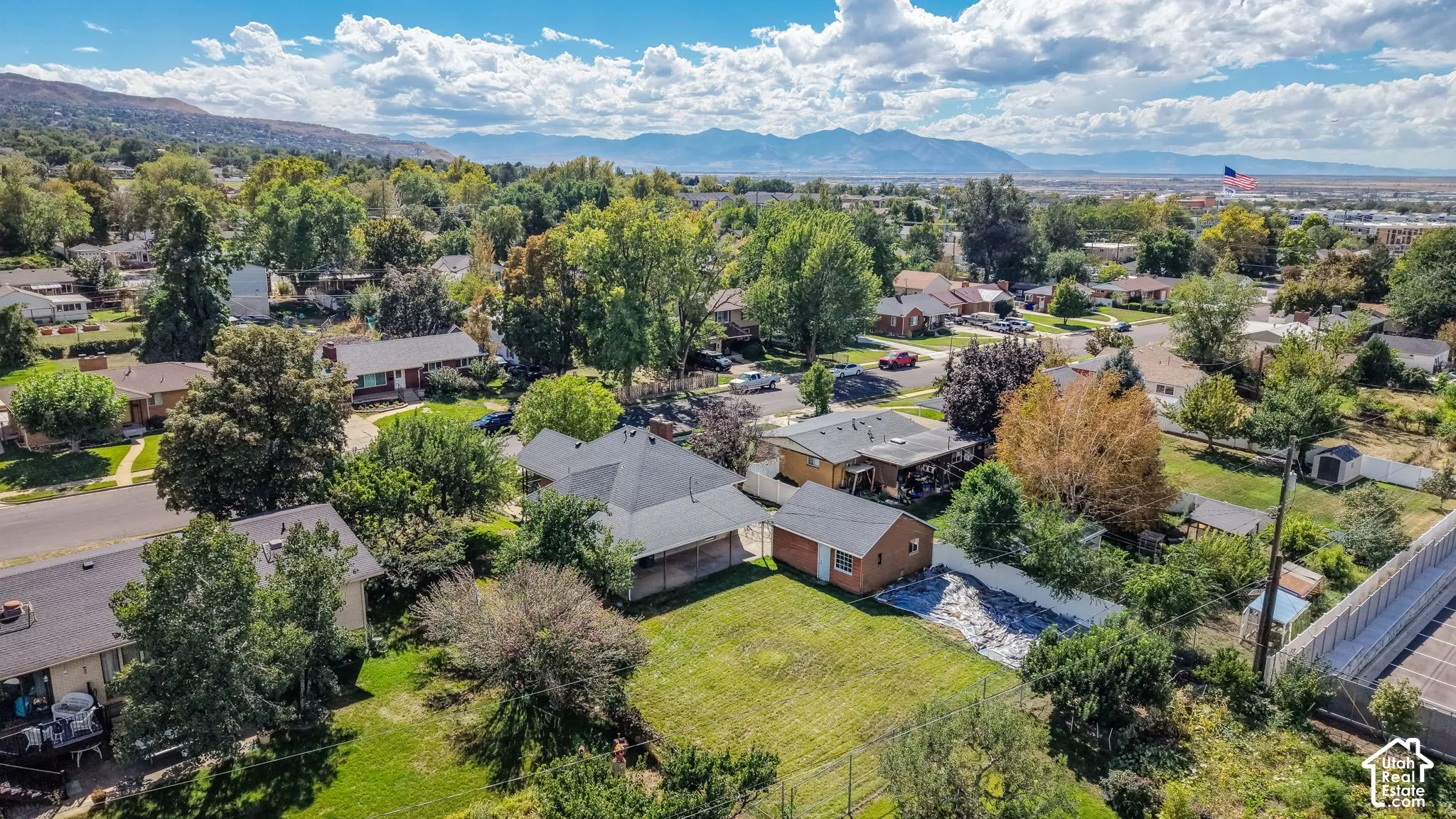 Expansive neighborhood setting with mature trees and mountain scenery