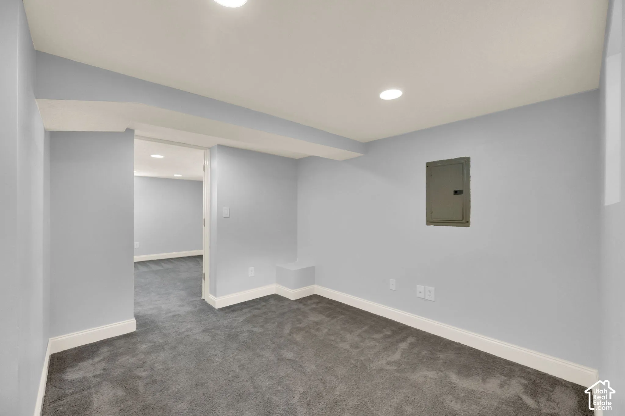 Recessed lighting and gray wall paint complement the gray carpeting