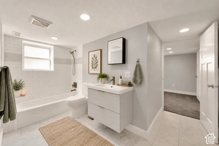 White subway tile shower surround with horizontal accent band, window, and full-size tub
