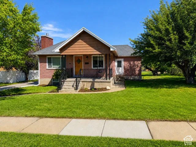 Front exterior with a red brick facade, wood-clad gable, and a covered porch