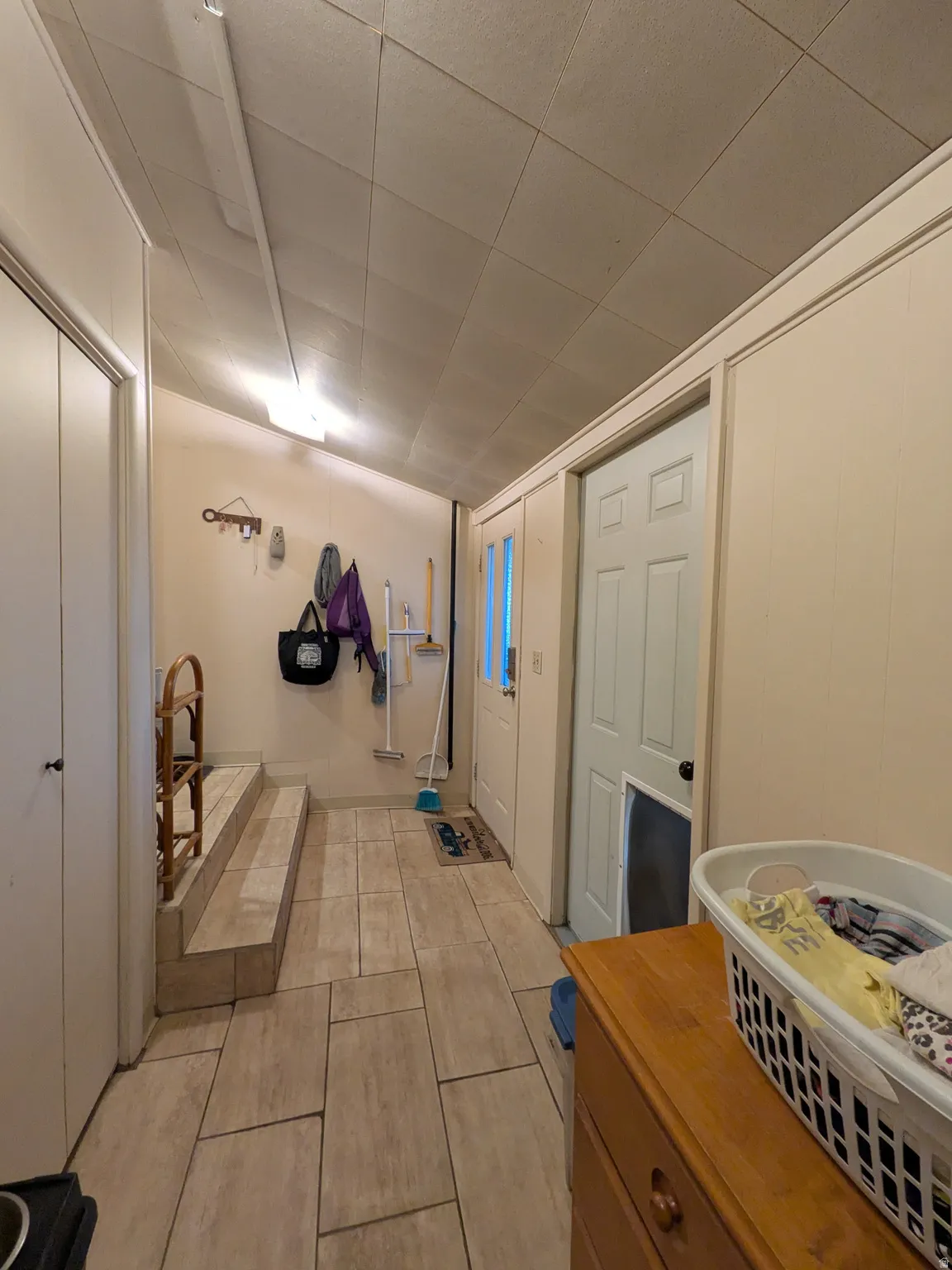 Tile flooring, built-in storage closets, and an exterior access door