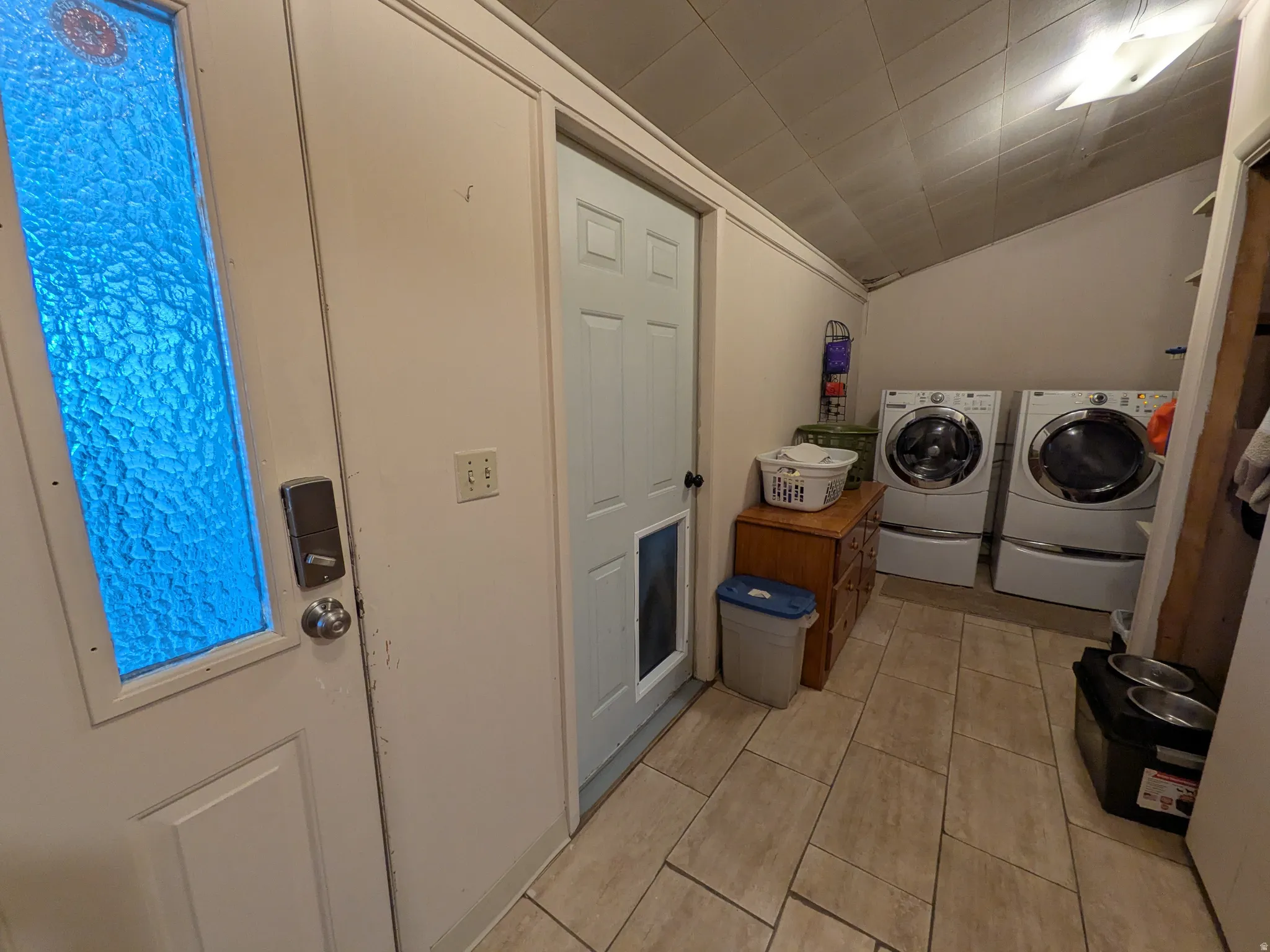 Tile flooring throughout with a white paneled door featuring textured glass