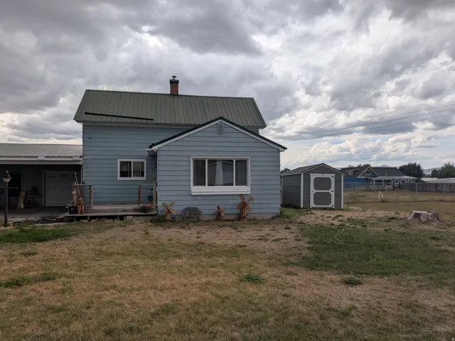 Light blue siding exterior with a green metal roof