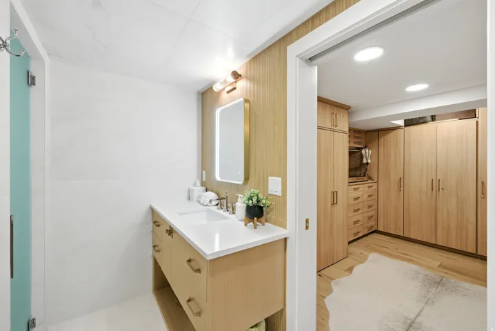 Wood-finish vanity with a white countertop and undermount sink