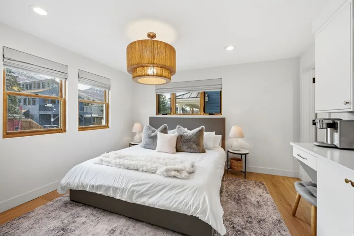 Wood-finish flooring, recessed lighting, and a tiered chandelier