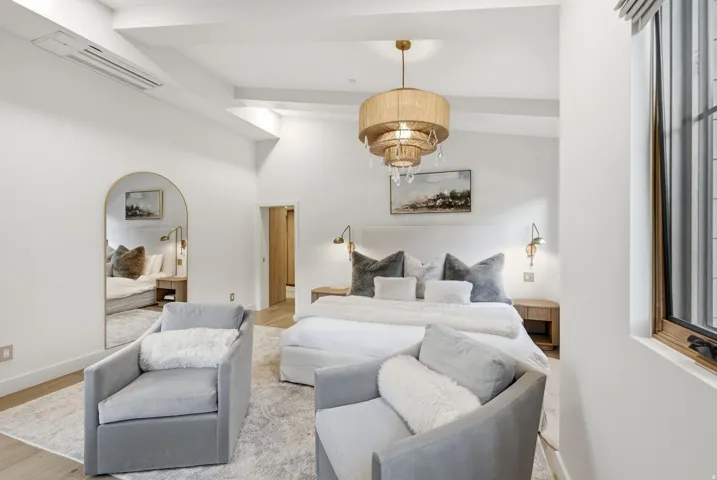 Vaulted ceiling with exposed beams, wood-finish flooring, recessed lighting, and a window with wood trim